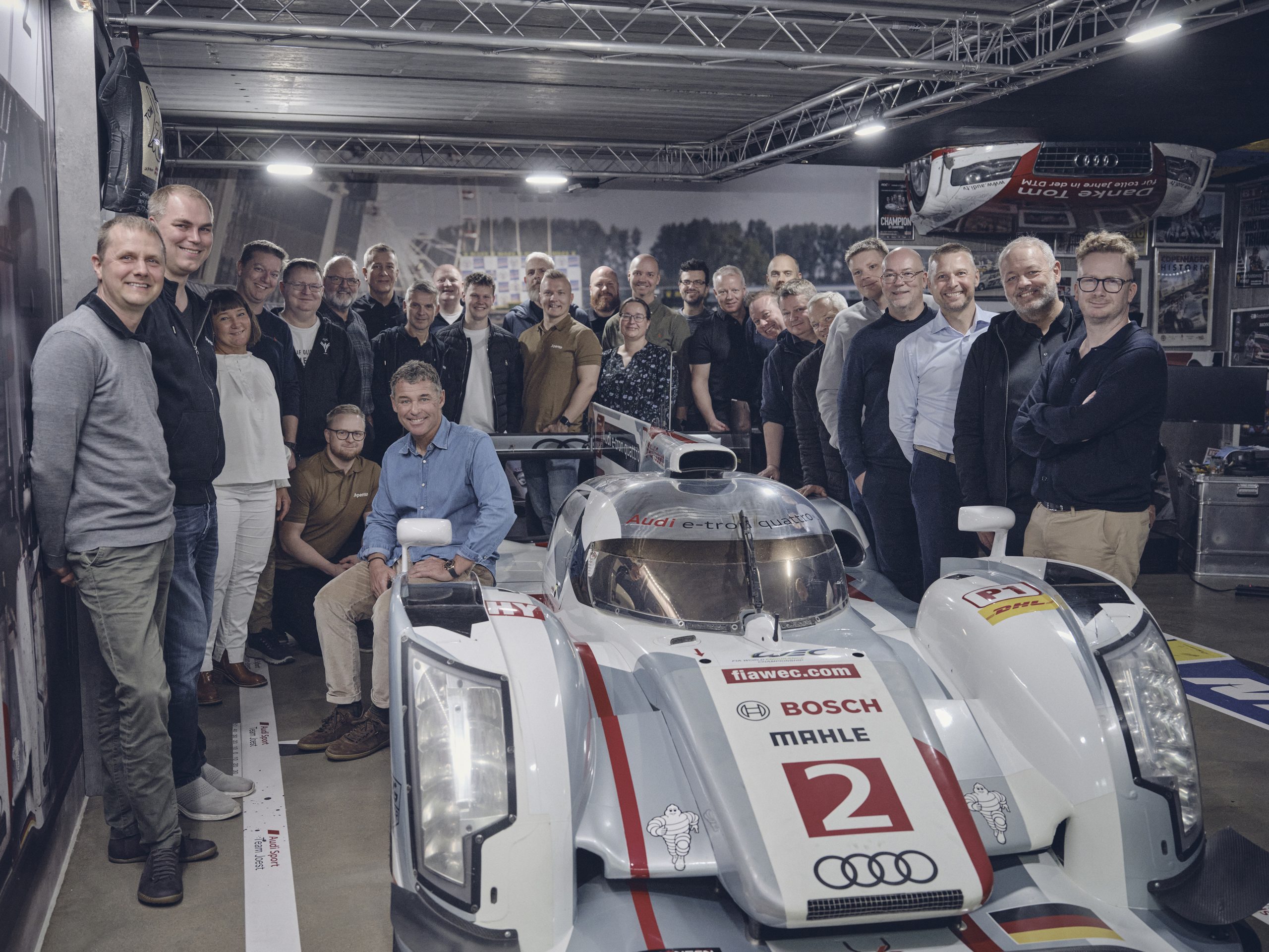 Apentos team samlet ved en Tom Kristensens Audi-racerbil