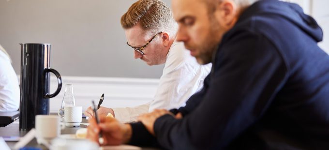 To deltagere arbejder ved et mødebord under en faglig gennemgang