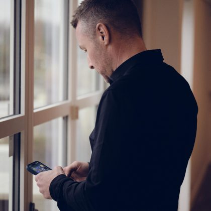 Apento-konsulent bruger telefon ved et vindue